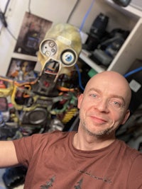 a bald man is taking a selfie with a robot