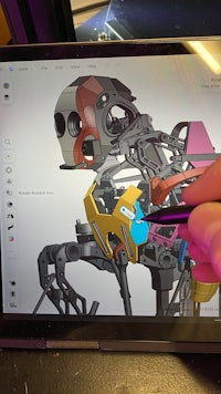 a person drawing a robot on a tablet computer