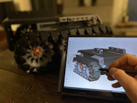 a person drawing a model of a vehicle on a tablet
